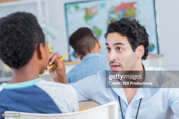 male teacher disciplines student in class - student uprising stock pictures, royalty-free photos & images