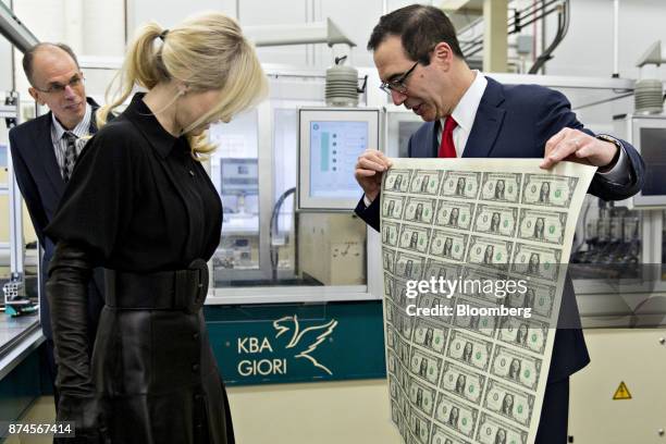 Steven Mnuchin, U.S. Treasury secretary, right, displays a 2017 50 subject uncut sheet of $1 dollar notes bearing Mnuchin's name for his wife Louise...