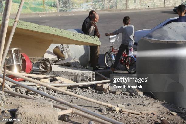 People are seen near a debris at Darbandikhan district of Suleymaniyah after an earthquake measuring 7.3 on the Richter scale rocked northern Iraq...