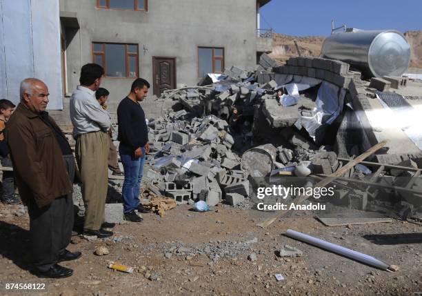 People inspect debris of a building at Darbandikhan district of Suleymaniyah after an earthquake measuring 7.3 on the Richter scale rocked northern...