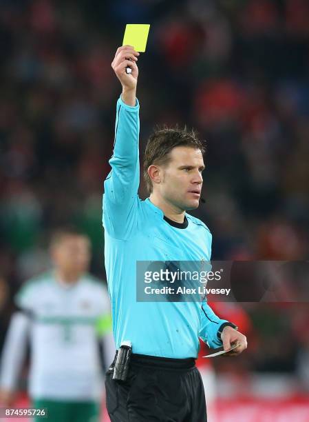 Referee, Felix Brych of Germany shows a yellow card during the FIFA 2018 World Cup Qualifier Play-Off second leg match between Switzerland and...