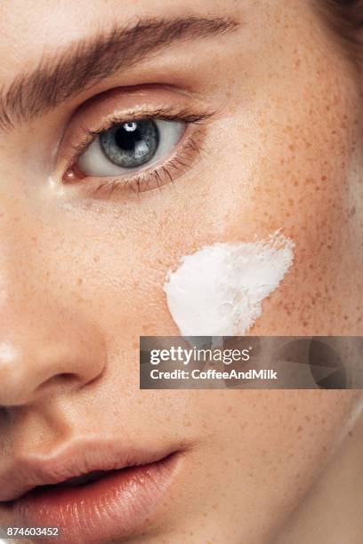 girl inflicting cream - pretty eye makeup for blue eyes stock pictures, royalty-free photos & images