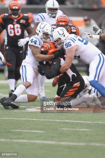 Antonio Morrison and Al Woods of the Indianapolis Colts make the tackle on Jeremy Hill of the Cincinnati Bengals during their game at Paul Brown...