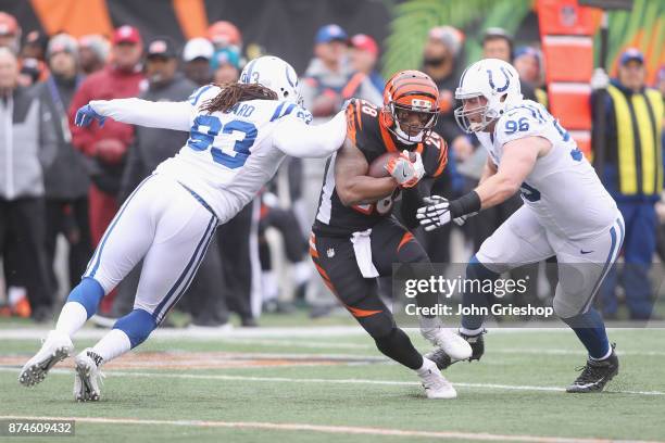 Joe Mixon of the Cincinnati Bengals runs the football upfield against Jabaal Sheard and Henry Anderson of the Indianapolis Colts during their game at...