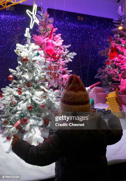 Child looks at the Christmas window display of the BHV Marais department store after the inauguration of the store's Christmas illuminations and...