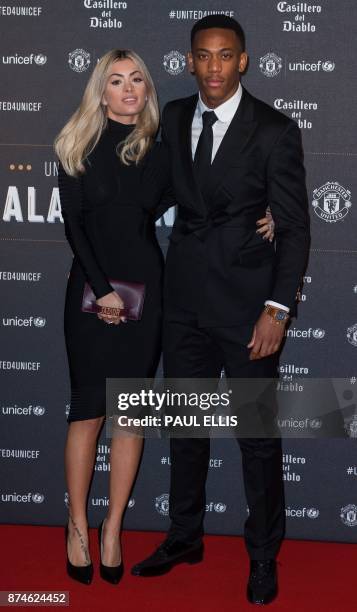 Manchester United's French striker Anthony Martial poses on the red carpet with Melanie Da Cruz as he arrives to attend the "United for UNICEF Gala...