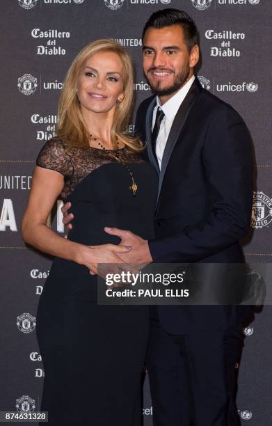 Manchester United's Argentinian goalkeeper Sergio Romero poses on the red carpet with Eliana Guercio as he arrives to attend the "United for UNICEF...