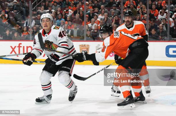 Travis Sanheim and Radko Gudas of the Philadelphia Flyers defend John Hayden of the Chicago Blackhawks on November 9, 2017 at the Wells Fargo Center...