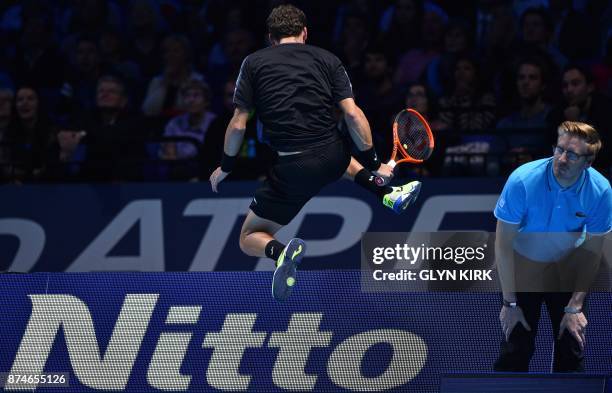 Spain's Pablo Carreno Busta hurdles the advertising hoardings after chasing the ball to play a shot against Austria's Dominic Thiem during their...