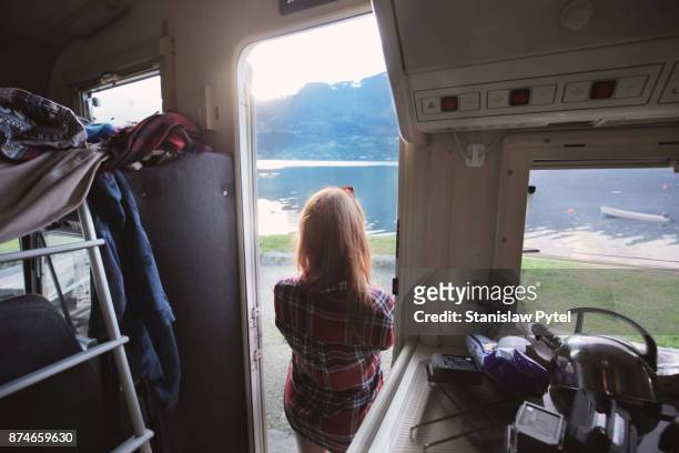 woman standing in doors of campervan admiring view - plaid shirt stock pictures, royalty-free photos & images