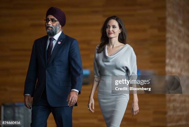 Harjit Sajjan, Canada's defense minister, left, walks with actress Angelina Jolie, special envoy to the United Nations High Commissioner for...