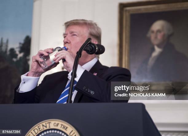 President Donald Trump drinks water from a bottle as he delivers remarks on November 15, 2017 in the Diplomatic Room at the White House in...