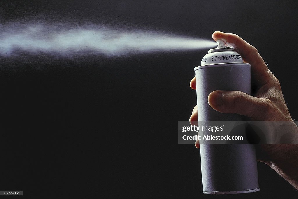 Person spraying aerosol can