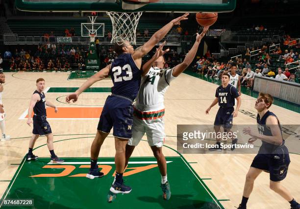 Navy forward Mo Lewis defends the shot of Miami center Rodney Miller, Jr. During a college basketball game between the Naval Academy Midshipmen and...