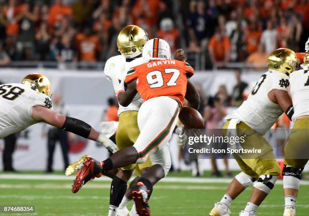 University of Miami defensive lineman Jonathan Garvin strips the ball from Notre Dame quarterback Brandon Wimbush during an NCAA football game...