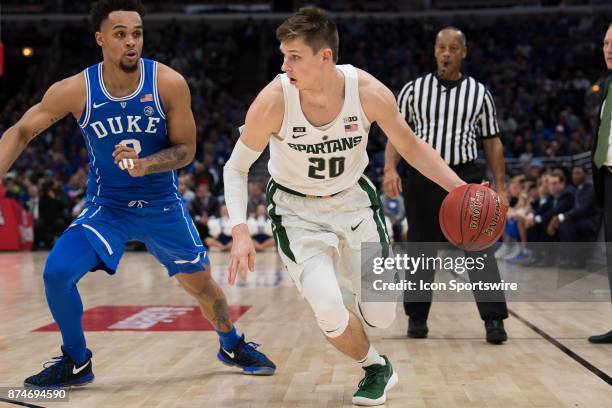 Michigan State Spartans guard Matt McQuaid drives by Duke Blue Devils guard Gary Trent, Jr. During the State Farm Champions Classic basketball game...