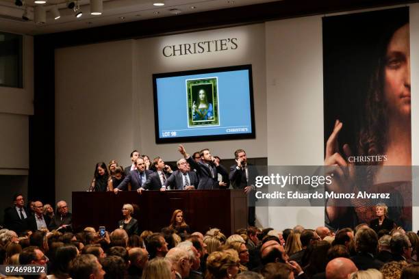 Agents speak on their phones with their clients while bidding on at the auction of Leonardo da Vinci's "Salvator Mundi" during the Post-War and...