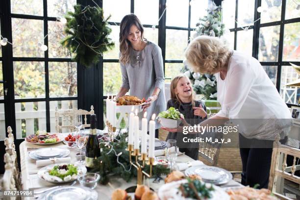 family enjoying preparing christmas - roast chicken table stock pictures, royalty-free photos & images