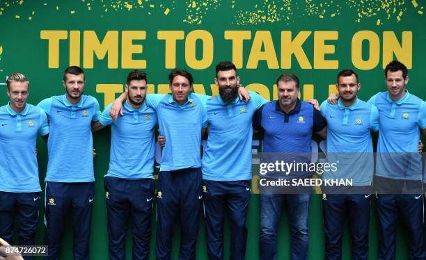 Australia's coach Ange Postecoglou and captain Mile Jedinak pose for photographs with teammates during an event to celebrate the national teams...