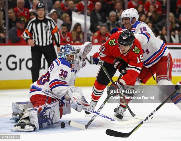 Artem Anisimov of the Chicago Blackhawks, pressured by Marc Staal of the New York Rangers, scores his second goal chasing Henrik Lundqvist from the...