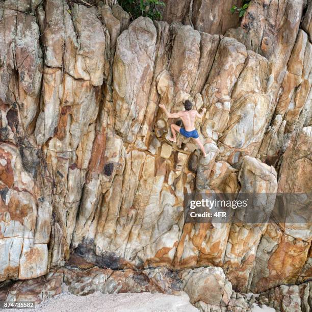 man free climbing, outdoor bouldering at the beach - krabi stock pictures, royalty-free photos & images