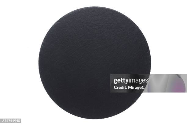 circle shape black stone plate on white - schist stock-fotos und bilder