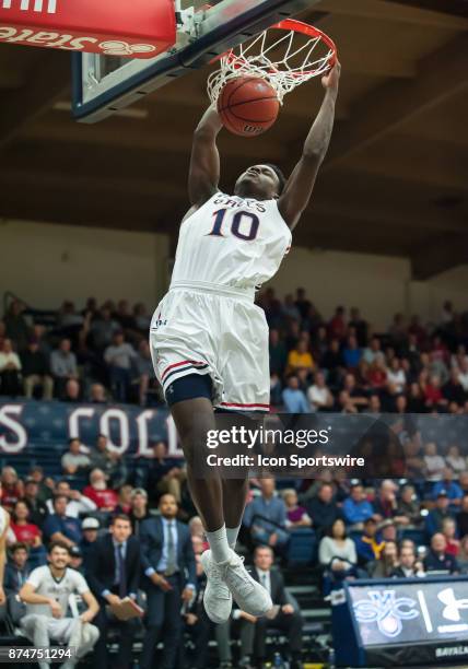 St. Mary's Gaels forward Elijah Thomas hangs onto the rim after dunking in the second half during the game between the St. Mary's Gaels and the Cal...