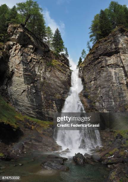 vertical view with rainbow and waterfall along devero mountain stream - deep ravine stock pictures, royalty-free photos & images