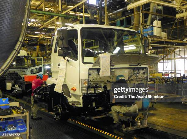 Workers assemble trucks at the production line at Mitsubishi Fuso Truck and Bus Corp Kawasaki Factory on November 15, 2017 in Kawasaki, Kanagawa,...