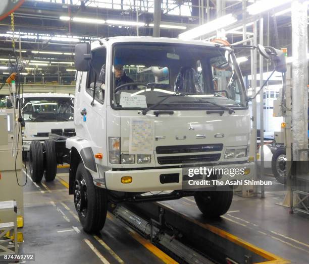 Workers assemble trucks at the production line at Mitsubishi Fuso Truck and Bus Corp Kawasaki Factory on November 15, 2017 in Kawasaki, Kanagawa,...