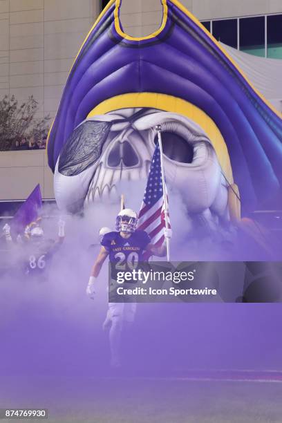 East Carolina Pirates wide receiver Ockwan Tyson-Hart carries the American Flag out of the East Carolina Pirates tunnel during pre-game activities at...