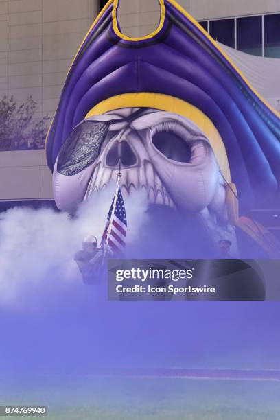 East Carolina Pirates wide receiver Ockwan Tyson-Hart carries the American Flag out of the East Carolina Pirates tunnel during pre-game activities at...