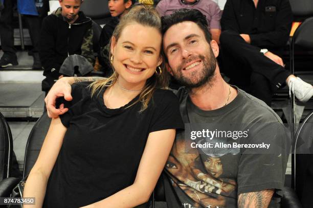 Model Behati Prinsloo and singer Adam Levine attend a basketball game between the Los Angeles Lakers and the Philadelphia 76ers at Staples Center on...