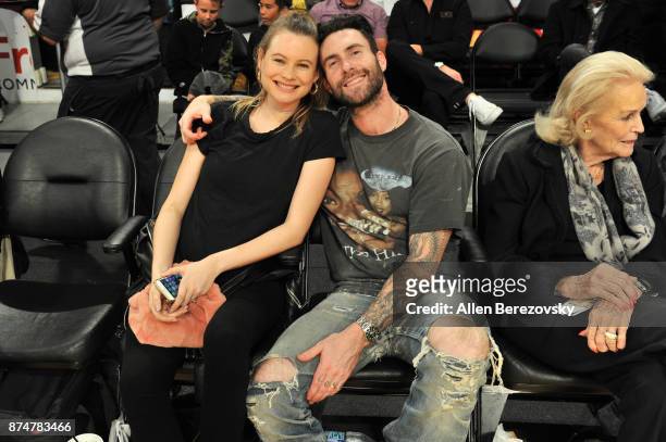 Model Behati Prinsloo and singer Adam Levine attend a basketball game between the Los Angeles Lakers and the Philadelphia 76ers at Staples Center on...