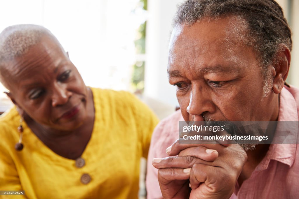 Senior Woman Comforting Man With Depression At Home