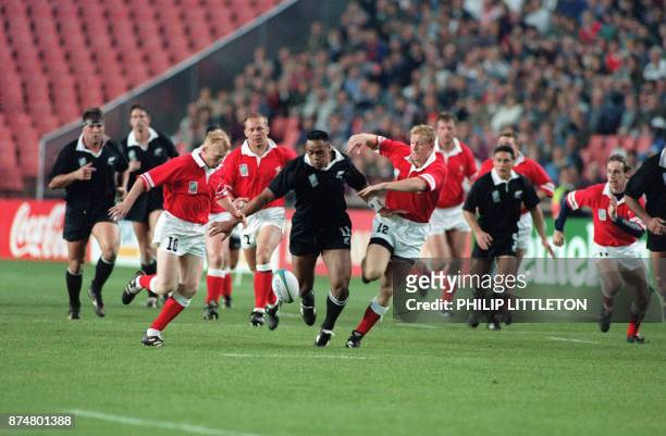 All Blacks Jonah Lomu is chased by Wales Neil Jenkins , forward Bennett and centre Gareth Thomas as he runs after a loose ball during the Rugby World...