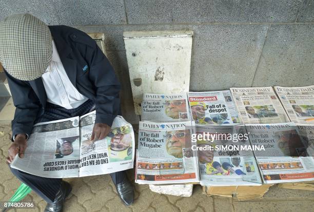 Man reads a local daily next to others with headlines about the situation in Zimbabwe on November 16 in Nairobi. Zimbabweans were weighing an...