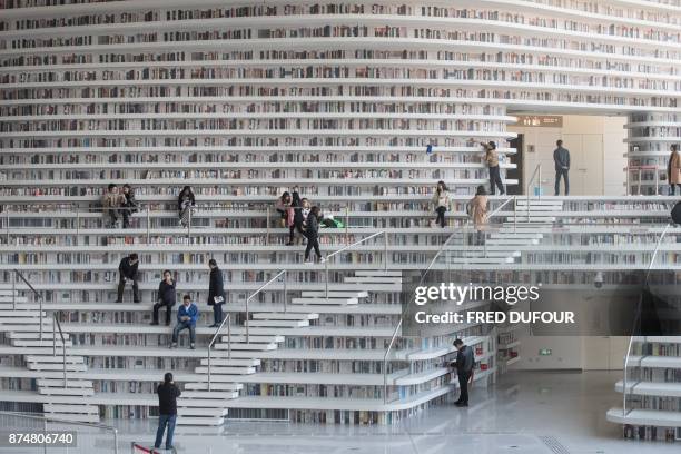 This picture taken on November 14, 2017 shows people visiting the Tianjin Binhai Library. A futuristic Chinese library has wowed book lovers around...