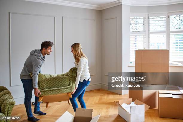 geven hun nieuwe huis een vleugje moderne flair met stijlvol meubilair - couple on sofa stockfoto's en -beelden