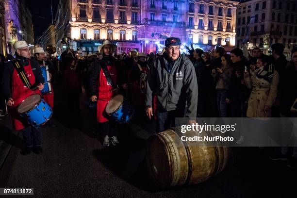 Barrels of Beaujolais Nouveau wine are rolled by wine-growers on November 15, 2017 in the streets of Lyon, France, during the official launch of the...