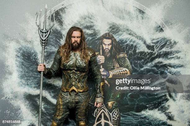 The character Aquaman from the Justice League film poses in character infront of film based promotional artwork unveiled for the first time during a...
