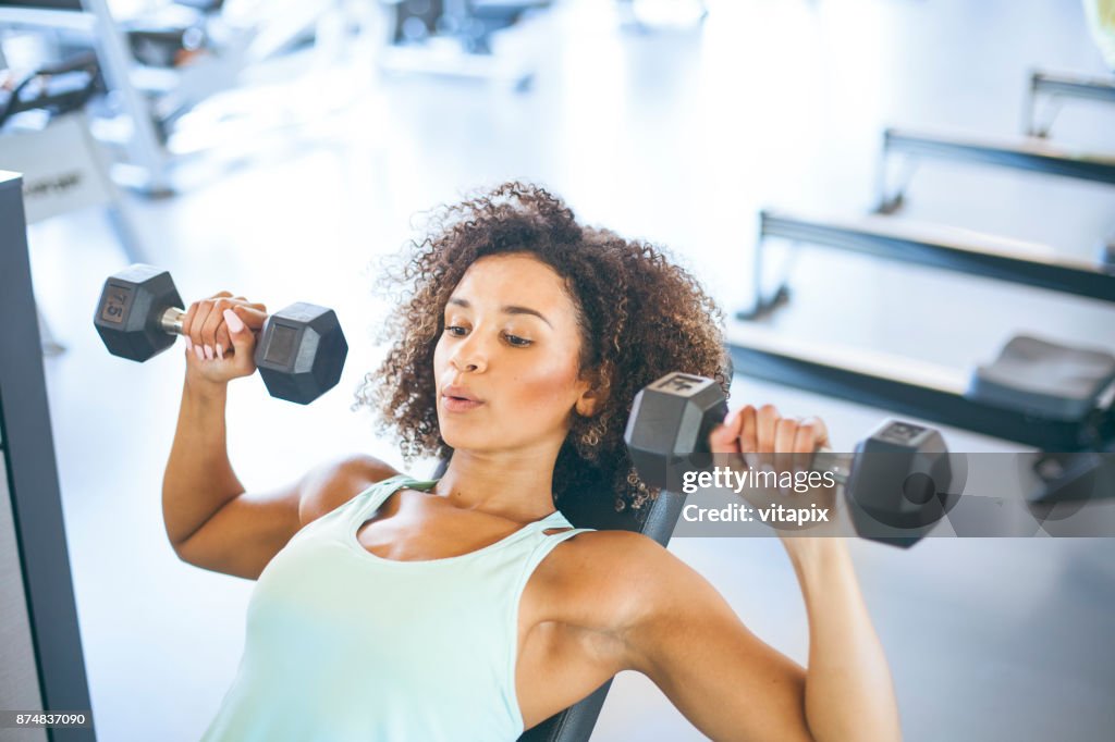 Ung kvinna Weightraining på gymmet