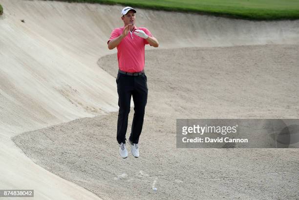 Justin Rose of England leaps in the air to try and see the line for his second shot on the third hole during the first round of the DP World Tour...