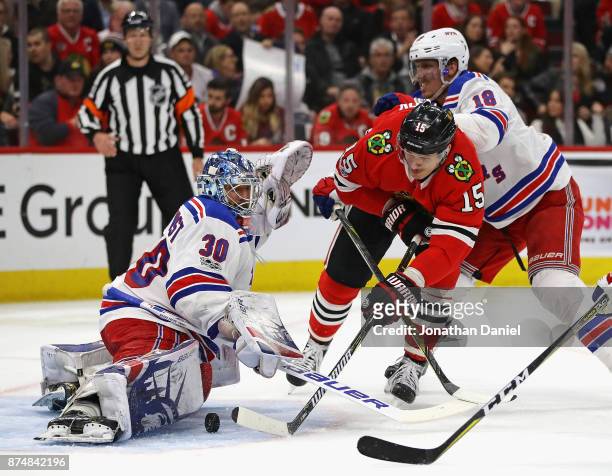 Artem Anisimov of the Chicago Blackhawks, pressured by Marc Staal of the New York Rangers, scores his second goal chasing Henrik Lundqvist from the...