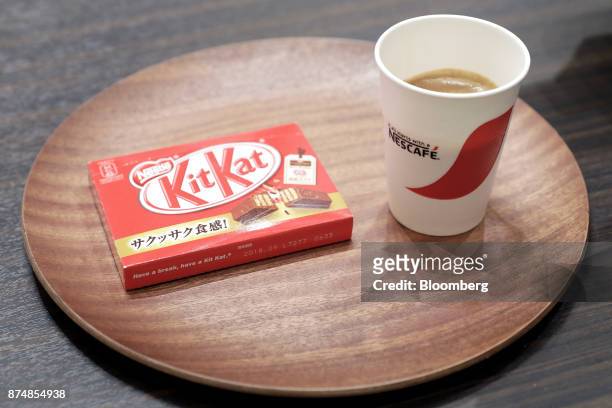 Cup of coffee and a box of KitKat chocolate bars sit on a tray during a media preview of the human-less cafe inside Nestle SA's Nescafe coffee shop...