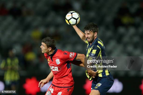 George Blackwood of Adelaide contests the ball against Anthony Golec of the Mariners during the round seven A-League match between the Central Coast...