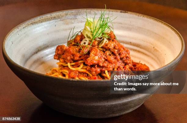 close up of a ceramic dish with spaghetti all sugo. - sugo pomodoro stock pictures, royalty-free photos & images