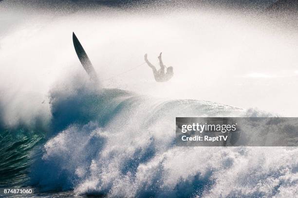 a surfer in mid air on a big wave. - big wave surfing stock-fotos und bilder