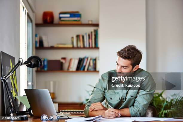 writing down his plan of action - man working from home stock pictures, royalty-free photos & images