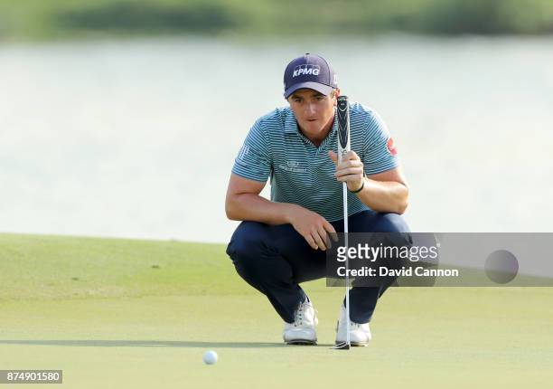 Paul Dunne of Ireland lines up a putt on the 17th hole during the first round of the DP World Tour Championship on the Earth Course at Jumeirah Golf...
